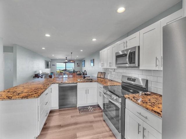 77-6585 Seaview Cir Unit 206, Kailua-Kona, HI 96740 - kitchen with stainless steel appliances, a sink, a peninsula, light wood-style floors, and recessed lighting