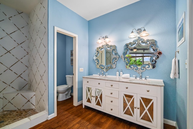 3920 Wyllie Rd Unit 7B, Princeville, HI 96722 - full bathroom with double vanity, wood finished floors, toilet, a tile shower, and baseboards