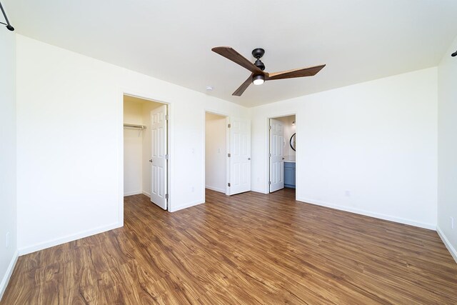 18-4259 Pszyk Rd, Mountain View, HI 96771 - unfurnished bedroom featuring baseboards, wood finished floors, a closet, and a walk in closet