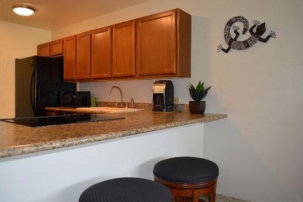 75-5865 Walua Rd Unit E-731, Kailua-Kona, HI 96740 - kitchen featuring black appliances, brown cabinetry, and a sink