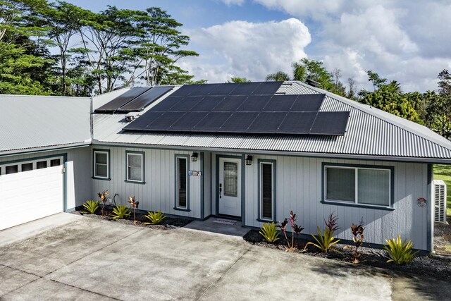 15-1697 7th Ave, Keaau, HI 96749 - view of front of home featuring a garage, metal roof, driveway, and roof mounted solar panels