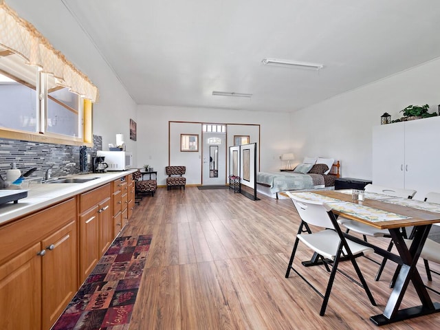94-6543 Kamaoa Rd, Naalehu, HI 96772 - kitchen featuring tasteful backsplash, wood finished floors, white microwave, light countertops, and a sink