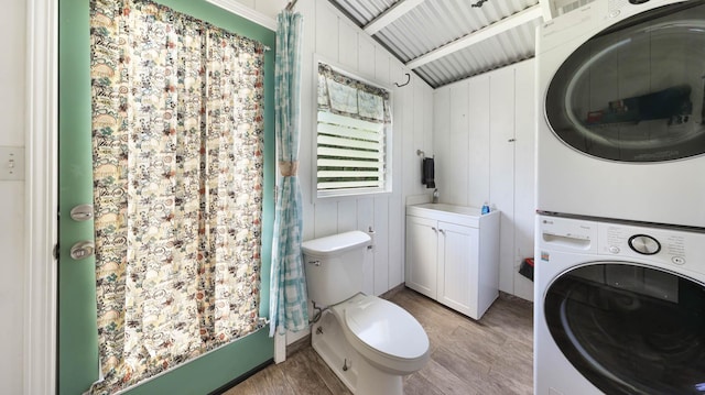 7990 Ulili Rd Unit A, Kekaha, HI 96752 - bathroom featuring stacked washing machine and dryer, wood finished floors, toilet, and curtained shower