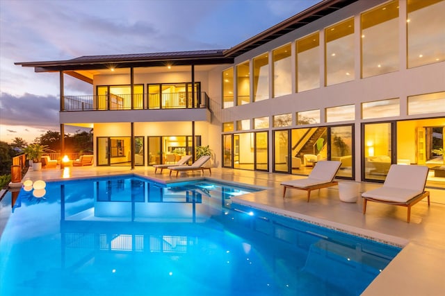 76-981 Aeo St, Kailua-Kona, HI 96740 - back of house featuring a balcony, a patio area, an outdoor pool, an in-ground hot tub, and a standing seam roof