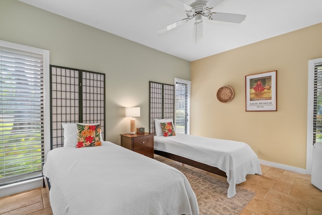 2370 Hoohu Rd Unit 712, Koloa, HI 96756 - bedroom with stone tile floors, multiple windows, baseboards, and ceiling fan