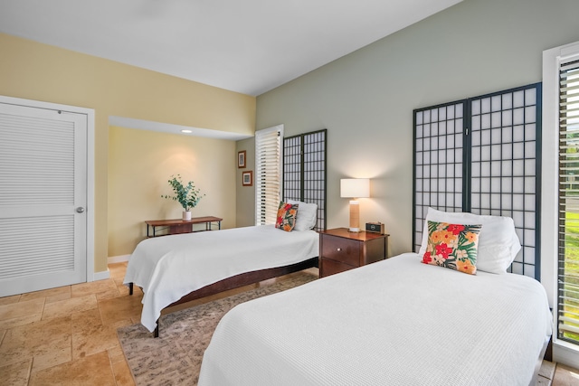 2370 Hoohu Rd Unit 712, Koloa, HI 96756 - bedroom featuring stone tile flooring, multiple windows, and baseboards