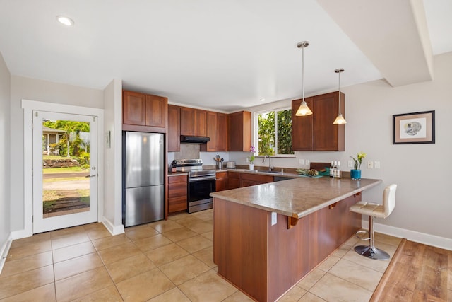 1165 Milia St, Kalaheo, HI 96741 - kitchen featuring stainless steel appliances, a peninsula, exhaust hood, a sink, and baseboards