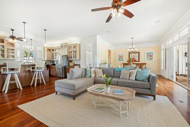 3042 Lauae Pl, Koloa, HI 96756 - living room featuring a ceiling fan, dark wood-style floors, a chandelier, ornamental molding, and baseboards