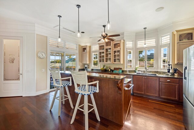 3042 Lauae Pl, Koloa, HI 96756 - kitchen with stainless steel refrigerator with ice dispenser, dark wood-style floors, glass insert cabinets, a kitchen bar, and ornamental molding