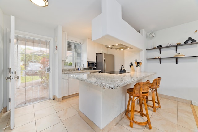 75-6081 Alii Dr Unit D104, Kailua-Kona, HI 96740 - kitchen featuring stainless steel appliances, a peninsula, a breakfast bar area, premium range hood, and light tile patterned flooring