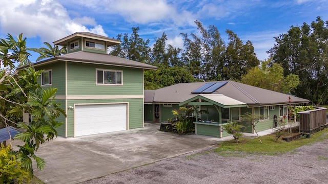 15-1545 27th Ave, Keaau, HI 96749 - view of front of home featuring concrete driveway, a garage, and roof mounted solar panels