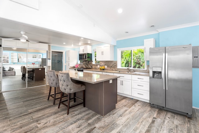74-4967 Kiwi St, Kailua-Kona, HI 96740 - kitchen featuring appliances with stainless steel finishes, ornamental molding, a sink, a kitchen island, and white cabinets