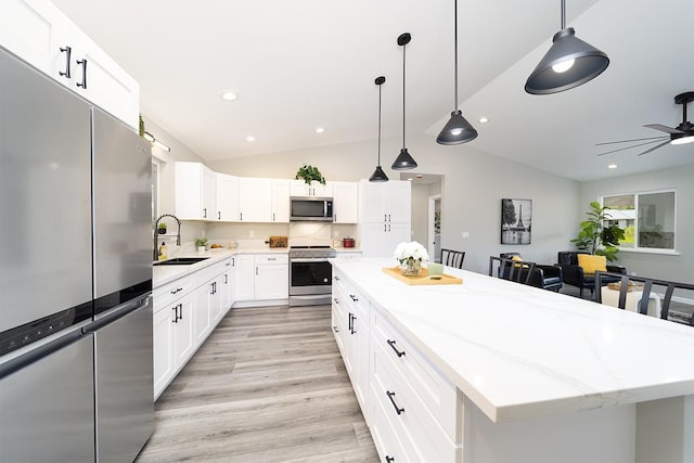 15-1987 27th Ave, Keaau, HI 96749 - kitchen featuring stainless steel appliances, vaulted ceiling, a center island, light wood-type flooring, and light stone counters