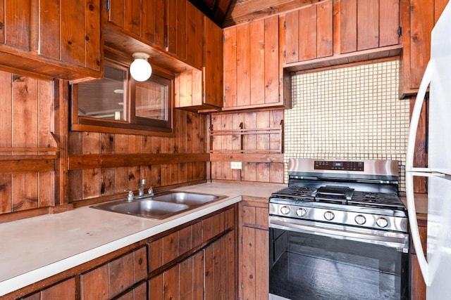 72-981 Puukala Rd, Kailua-Kona, HI 96740 - kitchen featuring stainless steel range with gas cooktop, a sink, light countertops, freestanding refrigerator, and wood walls