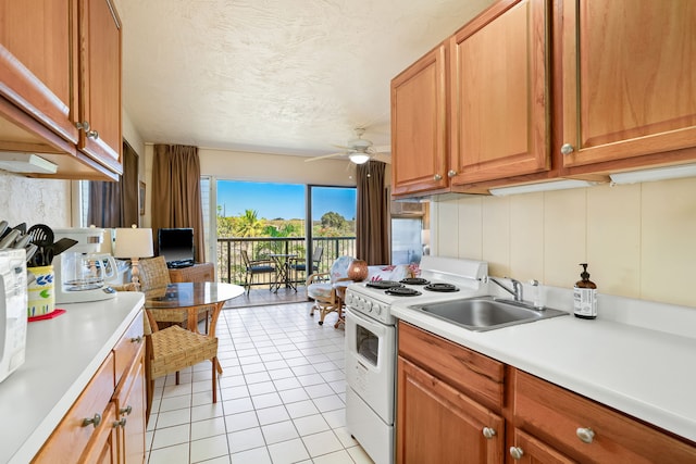 5061 Lawai Rd Unit 333, Koloa, HI 96756 - kitchen featuring white range with electric cooktop, a sink, a ceiling fan, light countertops, and light tile patterned floors