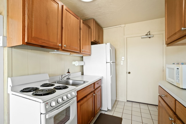 5061 Lawai Rd Unit 333, Koloa, HI 96756 - kitchen with white appliances, a sink, light countertops, light tile patterned flooring, and brown cabinets