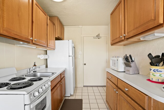 5061 Lawai Rd Unit 333, Koloa, HI 96756 - kitchen featuring white appliances, a sink, light countertops, brown cabinets, and a textured ceiling