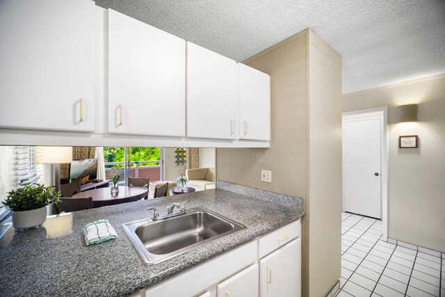 525 Aleka Lp Unit C13, Kapaa, HI 96746 - kitchen with a sink, light tile patterned floors, a textured ceiling, white cabinets, and light countertops