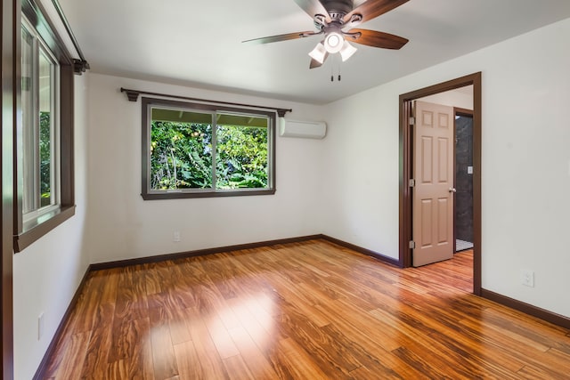 4085-B Noho Rd, Koloa, HI 96756 - empty room with wood finished floors, baseboards, a wall unit AC, and a ceiling fan
