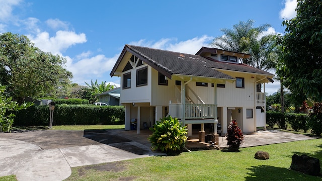 4085-B Noho Rd, Koloa, HI 96756 - back of property featuring a lawn, concrete driveway, stairway, a tiled roof, and a patio