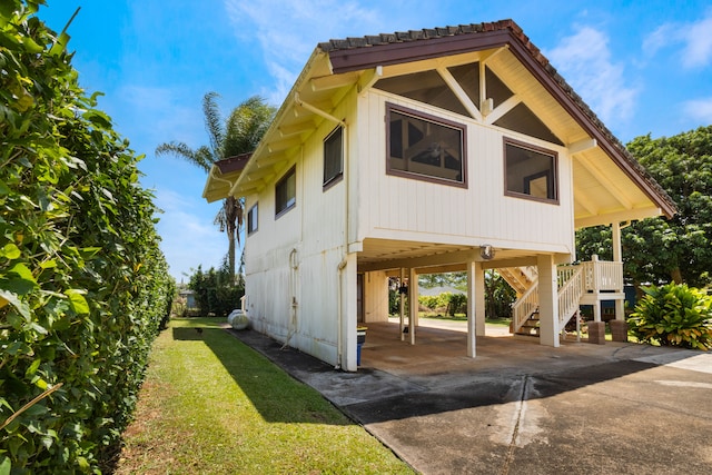 4085-B Noho Rd, Koloa, HI 96756 - view of home's exterior featuring stairway, a carport, concrete driveway, and a yard