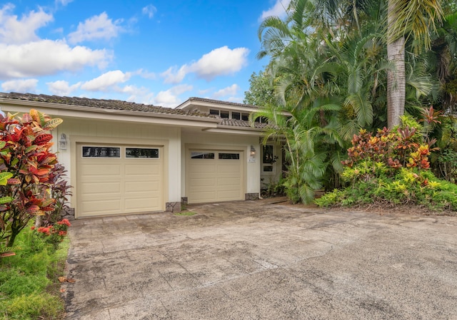 4194 Waileia Pl, Princeville, HI 96722 - view of side of home featuring driveway, an attached garage, and a tiled roof
