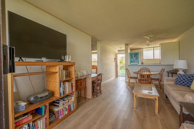 1875 Kalanianaole Ave Unit 409, Hilo, HI 96720 - living area featuring wood finished floors, concrete block wall, a textured ceiling, and a ceiling fan
