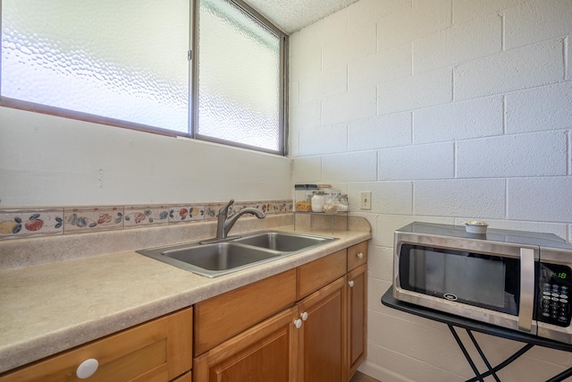 1875 Kalanianaole Ave Unit 409, Hilo, HI 96720 - kitchen with stainless steel microwave, a sink, light countertops, and brown cabinets