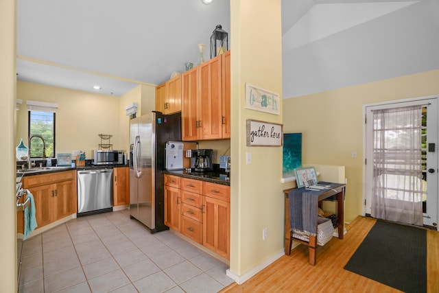 5451 Ka Haku Rd Unit 24, Princeville, HI 96722 - kitchen with stainless steel appliances, dark countertops, a sink, high vaulted ceiling, and light tile patterned flooring