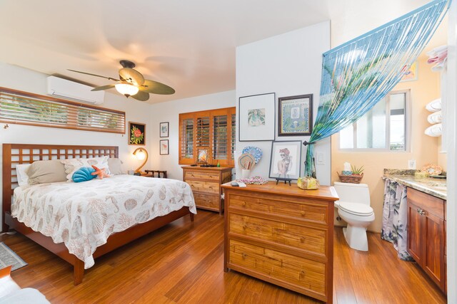 78-6655 Alii Dr, Kailua-Kona, HI 96740 - bedroom featuring a wall mounted AC, wood finished floors, and ceiling fan