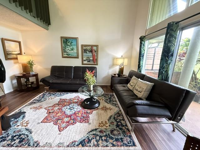 3880 Wyllie Rd Unit 8C, Princeville, HI 96722 - living area featuring wood finished floors, baseboards, and a high ceiling