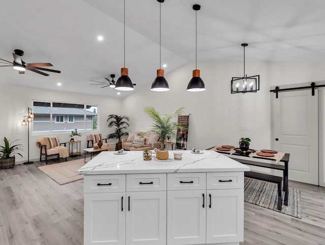 16-2112 Tangerine Dr, Pahoa, HI 96778 - kitchen with a barn door, light wood-style floors, a ceiling fan, white cabinets, and open floor plan