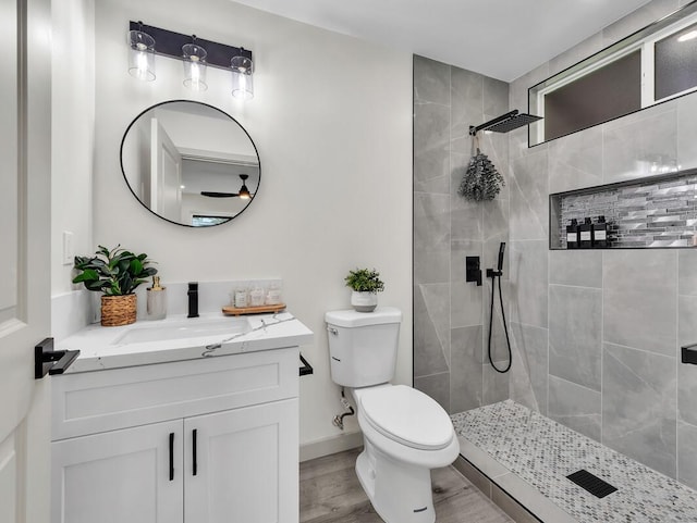 16-2112 Tangerine Dr, Pahoa, HI 96778 - bathroom featuring vanity, a tile shower, toilet, wood finished floors, and baseboards