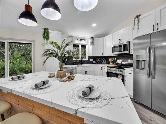 16-2112 Tangerine Dr, Pahoa, HI 96778 - kitchen featuring appliances with stainless steel finishes, tasteful backsplash, healthy amount of natural light, light stone countertops, and recessed lighting
