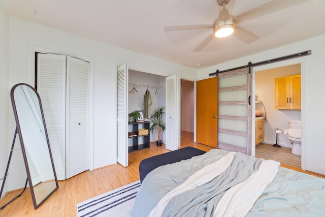 15-1506 23rd Ave, Keaau, HI 96749 - bedroom featuring multiple closets, a barn door, light wood-style floors, and ensuite bath