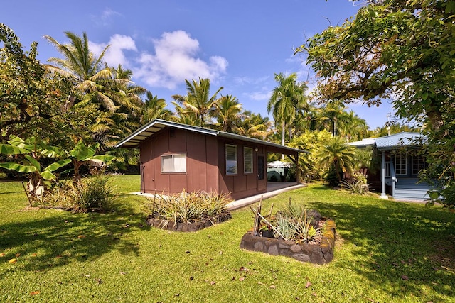 13-125 Nalu Pl, Pahoa, HI 96778 - view of property exterior with board and batten siding and a lawn