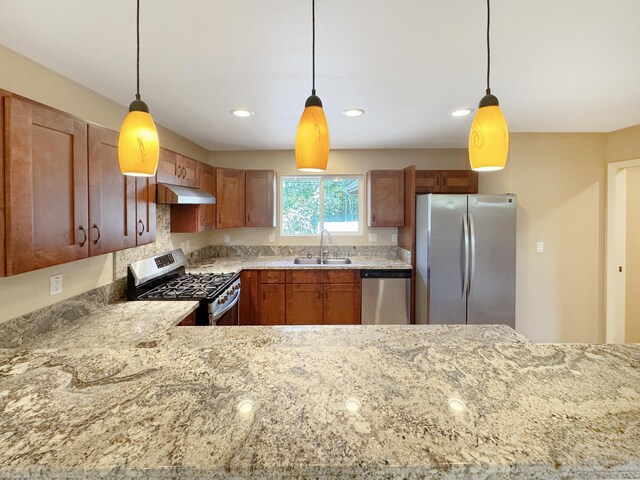 15-1580 17th Ave, Keaau, HI 96749 - kitchen with appliances with stainless steel finishes, a sink, under cabinet range hood, light stone countertops, and decorative light fixtures
