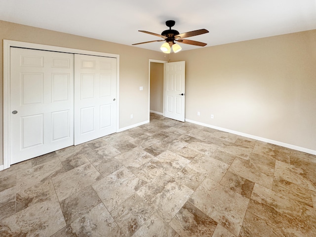 15-1580 17th Ave, Keaau, HI 96749 - unfurnished bedroom featuring stone finish flooring, baseboards, a closet, and a ceiling fan