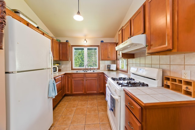 15-2021 11th Ave, Keaau, HI 96749 - kitchen with white appliances, under cabinet range hood, brown cabinets, tile counters, and vaulted ceiling