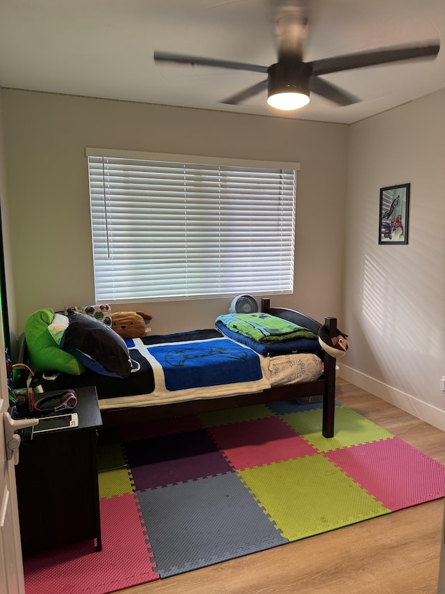 16-2062 Paradise Dr, Pahoa, HI 96778 - bedroom with wood finished floors, baseboards, a ceiling fan, and multiple windows