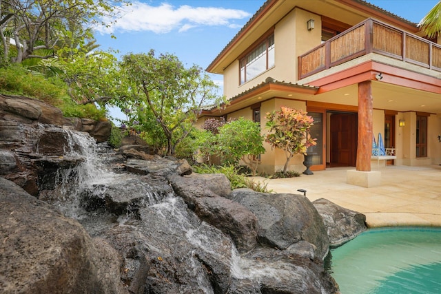 68-108 Pukaua Pl, Kamuela, HI 96743 - view of side of home with a balcony, a patio area, stucco siding, and a tile roof