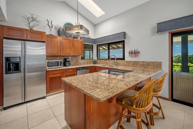 4282 Kalaheo Dr, Kalaheo, HI 96741 - kitchen featuring stainless steel appliances, a skylight, high vaulted ceiling, a sink, and brown cabinets