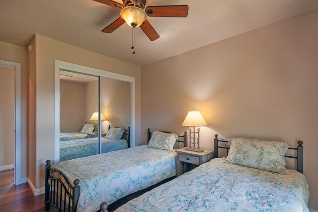 3636 Keoniana Rd, Princeville, HI 96722 - bedroom with dark wood-type flooring, baseboards, a closet, and a ceiling fan