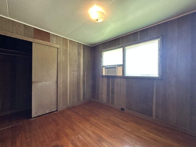 5684 Wailaau Rd, Koloa, HI 96756 - unfurnished bedroom featuring wood finished floors, a closet, wooden walls, and cooling unit