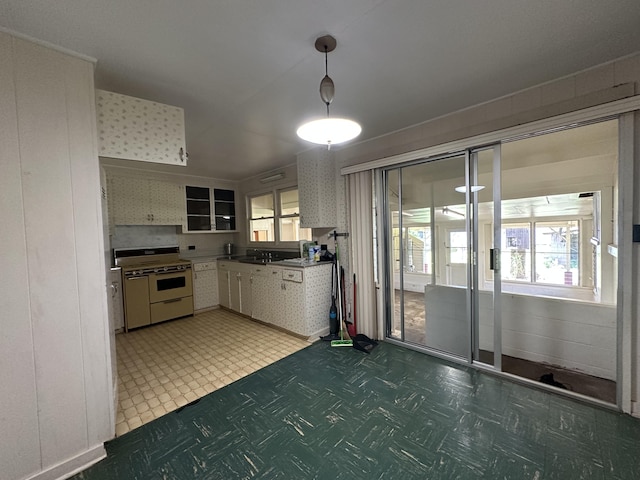 5684 Wailaau Rd, Koloa, HI 96756 - kitchen with white range with gas cooktop, light floors, white cabinets, pendant lighting, and glass insert cabinets