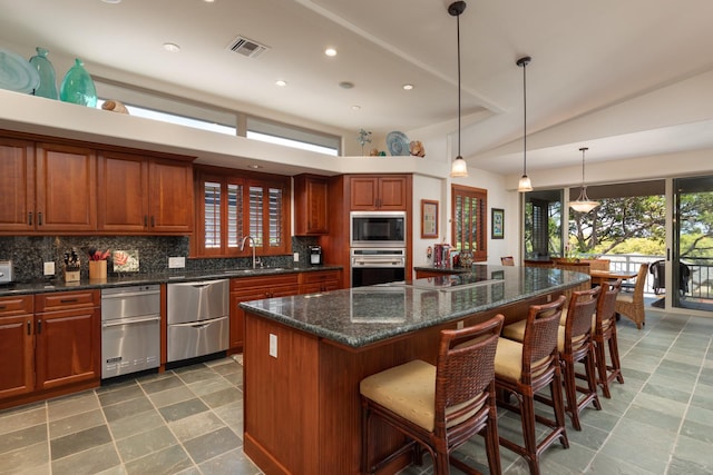 68-1025 Kaniku Dr Unit 612, Kamuela, HI 96743 - kitchen featuring appliances with stainless steel finishes, a sink, decorative backsplash, recessed lighting, and a kitchen bar