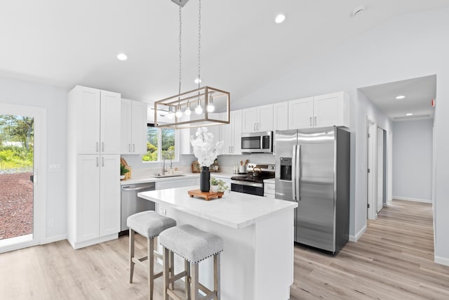 15-1754 Paradise Dr, Keaau, HI 96749 - kitchen featuring appliances with stainless steel finishes, a sink, a kitchen island, vaulted ceiling, and a kitchen bar