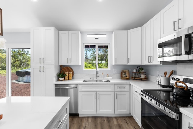 15-1754 Paradise Dr, Keaau, HI 96749 - kitchen with appliances with stainless steel finishes, a sink, light countertops, dark wood finished floors, and white cabinets