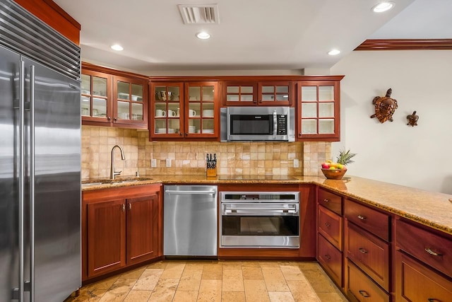 4-820 Kuhio Hwy Unit C306, Kapaa, HI 96746 - kitchen featuring appliances with stainless steel finishes, tasteful backsplash, a sink, light stone counters, and recessed lighting