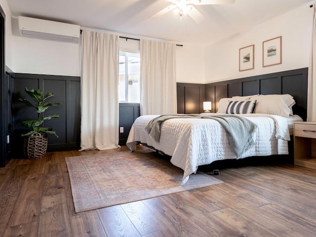 189 Poouli St, Wailuku, HI 96793 - bedroom featuring a wall mounted air conditioner, a decorative wall, a wainscoted wall, wood finished floors, and ceiling fan